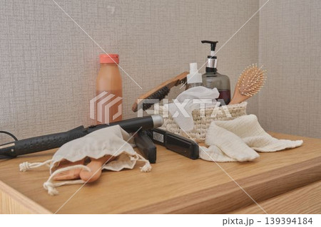 Hair styling tools and beauty products on wooden dresser Hair styling tools and beauty products on wooden dresser 139394184