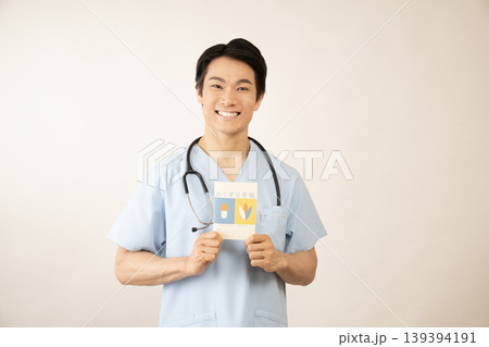 お薬手帳を持つ若い男性医師 お薬手帳を持つ若い男性医師 139394191