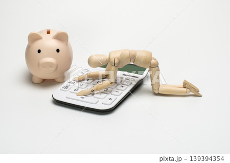 電卓にがっくりと膝をつくデッサン人形と豚の貯金箱 139394354