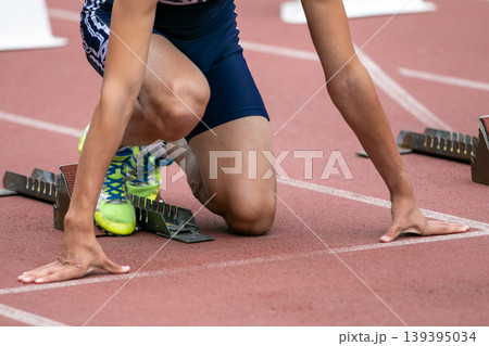 Athlete at low start from starting block 139395034