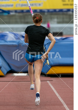 Female athlete with pole in her hands running Female athlete with pole in her hands running 139395037