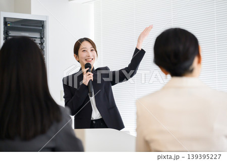 社員の前でプレゼンをする日本人女性 社員の前でプレゼンをする日本人女性 139395227