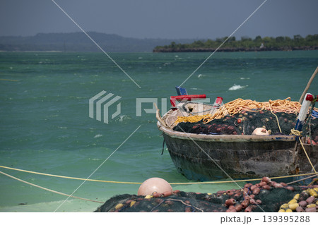 fishing wooden boat moored on the beach in Zanzibar at sunny day fishing wooden boat moored on the beach in Zanzibar at sunny day 139395288
