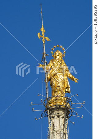 Madonnina golden statue of Virgin Mary on top of Milan Gothic Church sunny day 139395295