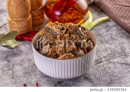 Homemade stewed liver with carrots and onions in a bowl on a gray stone background with spices. 139395361