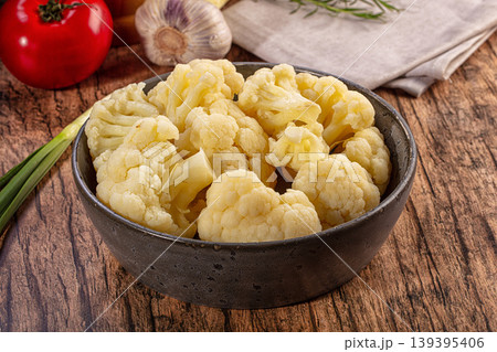 Fresh cauliflower florets in a ceramic bowl with raw vegetables on a rustic wooden table Fresh cauliflower florets in a ceramic bowl with raw vegetables on a rustic wooden table 139395406