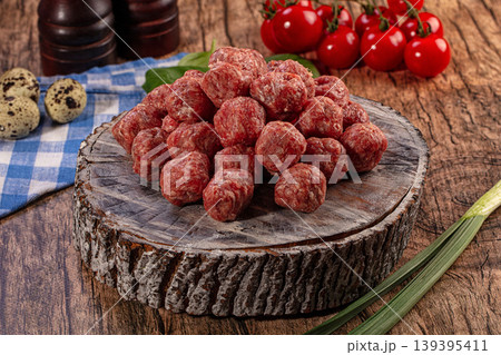 Raw Meatballs on Rustic Wooden Board with Tomatoes and Spices Raw Meatballs on Rustic Wooden Board with Tomatoes and Spices 139395411