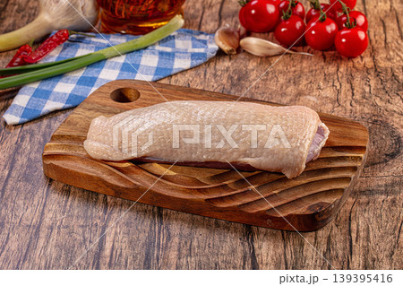 Raw duck breast fillet on wooden board with fresh vegetables and olive oil 139395416