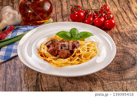 Spaghetti with meatballs and fresh basil, classic Italian pasta dish on rustic wooden table 139395418