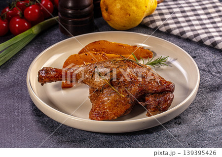 Roasted duck leg with baked pears and fresh rosemary on plate 139395426