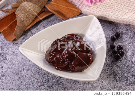 Rich Dark Chocolate Sauce in White Bowl with Berries and Cinnamon 139395454