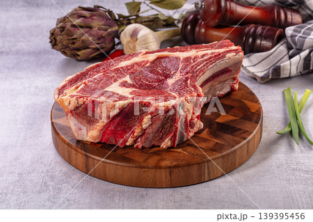 Raw Prime Rib Roast on Wooden Board with Culinary Ingredients 139395456