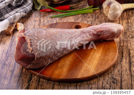 Uncooked turkey drumstick, garlic, chili peppers, green onions, bay leaves, rustic wood table 139395457