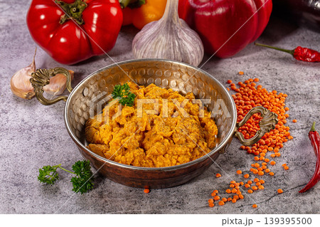 Spicy lentil puree in copper bowl with fresh ingredients Spicy lentil puree in copper bowl with fresh ingredients 139395500