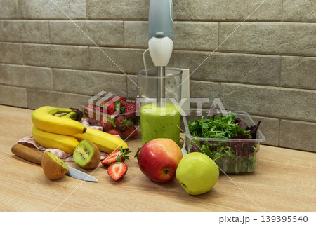 Preparing a healthy green smoothie with fresh fruits 139395540