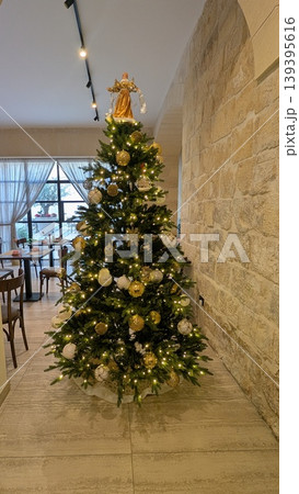 Christmas tree decorated with gold and white ornaments and lights 139395616