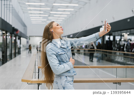 Fashionable Woman Capturing Selfie inside Large Shopping Center 139395644