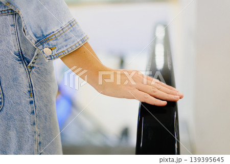 Customer Hand on Escalator Railing in Mall 139395645
