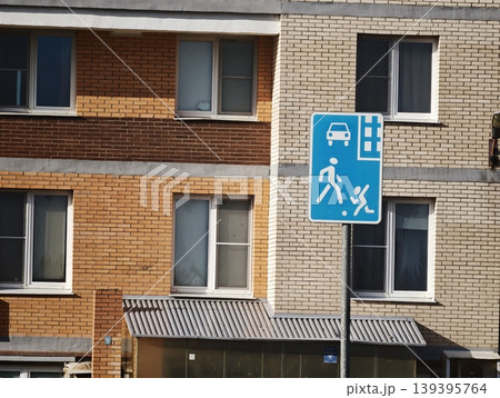 Traffic sign residential area and construction area in front of a residential building with brick facade and multiple windows 139395764