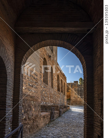 Ancient Brick Archway And Sunlit Fortress Corridor Through Arched Passageway In Historic Alhambra Ruins 139395803