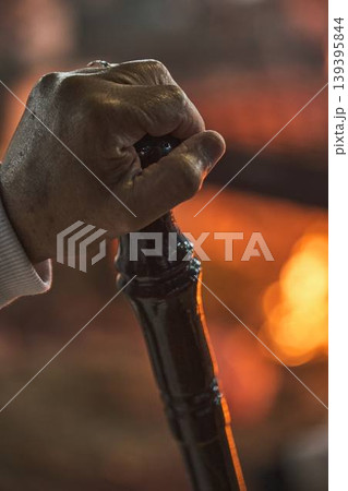 Hand holding traditional staff near fire during Samaritan Passover ritual Hand holding traditional staff near fire during Samaritan Passover ritual 139395844