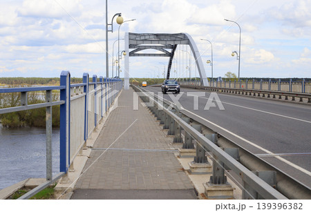 Arch bridge over the river during spring flood. Cargo transportation and logistics concept. Arch bridge over the river during spring flood. Cargo transportation and logistics concept. 139396382