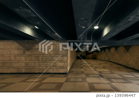 Geometric patterned floor and stone walls in a modern urban underground hallway 139396447