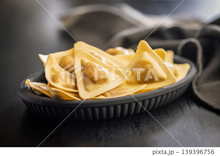 Fresh Triangular Ravioli On Black Plate - Golden Filled Pasta For Italian Cooking And Food Photography 139396756