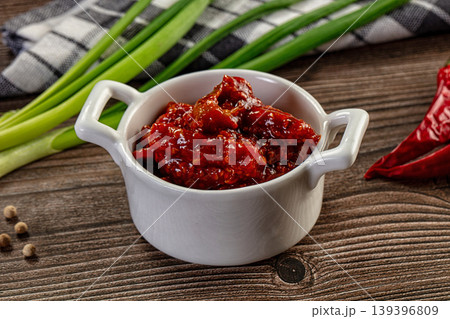 Spicy red chili pickle in a white bowl on a rustic wooden table with fresh ingredients Spicy red chili pickle in a white bowl on a rustic wooden table with fresh ingredients 139396809