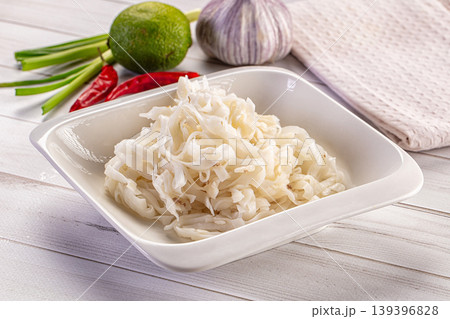 Fresh rice noodles and ingredients for Asian cuisine like chili, lime, and garlic on a white wooden table Fresh rice noodles and ingredients for Asian cuisine like chili, lime, and garlic on a white wooden table 139396828