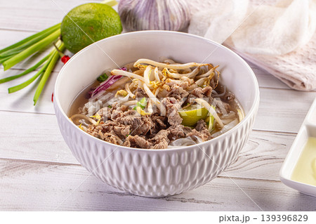Vietnamese Pho Bo noodle soup with beef and bean sprouts in a white bowl Vietnamese Pho Bo noodle soup with beef and bean sprouts in a white bowl 139396829