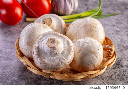 Raw champignon mushrooms in a basket with fresh vegetables for cooking 139396840