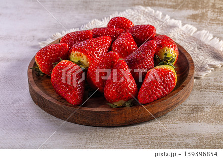 Fresh ripe strawberries on a rustic wooden plate Fresh ripe strawberries on a rustic wooden plate 139396854