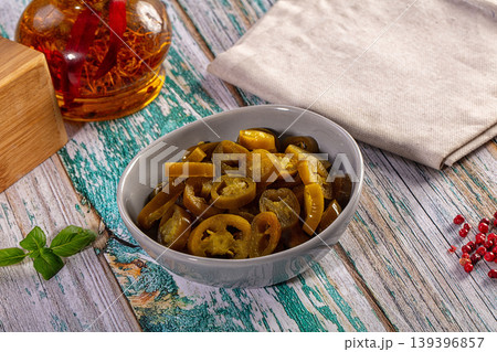 Sliced pickled jalapeno peppers in a bowl on a rustic table with spices and herbs Sliced pickled jalapeno peppers in a bowl on a rustic table with spices and herbs 139396857