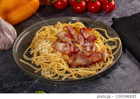 Spaghetti carbonara with crispy bacon and fresh ingredients on dark background Spaghetti carbonara with crispy bacon and fresh ingredients on dark background 139396885