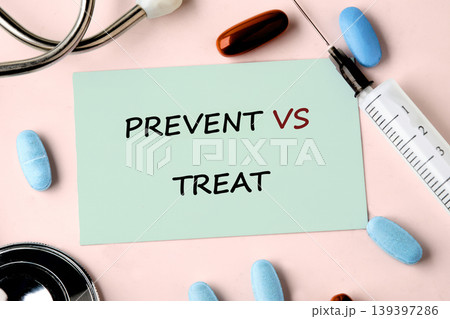 Green sticky note showing PREVENT VS TREAT on a pink surface. Blue oval pills, a brown capsule, a medical stethoscope, and a syringe lie near the important message 139397286