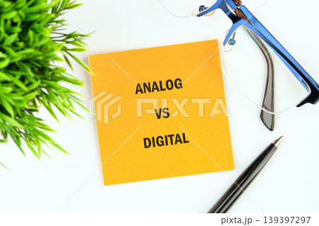 An orange sticky note presents the words ANALOG VS DIGITAL centrally An orange sticky note presents the words ANALOG VS DIGITAL centrally 139397297