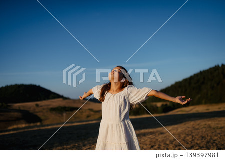 Rear view of a beautiful little girl feeling free in summer in nature. Rear view of a beautiful little girl feeling free in summer in nature. 139397981