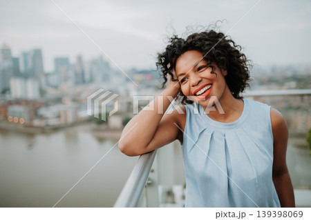 Portrait of a beautiful woman standing on terrace of modern building. 139398069