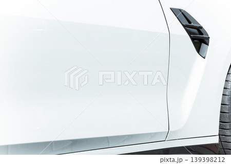 Close-up of a sleek white car's metallic body panel and vent detail 139398212