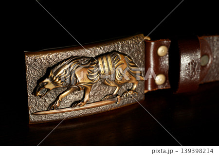 Ornate wolf iron forged male clasp for belt with textured background 139398214