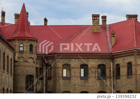 Old castle residence facade with red tiled roof and brickwork detail 139398232