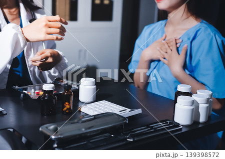 Female doctor holding a medicine bottle is checking the quality of medicine for any side effects the patient or not and recording patient information at the hospital. medical and health care concept Female doctor holding a medicine bottle is checking the quality of medicine for any side effects the patient or not and recording patient information at the hospital. medical and health care concept 139398572