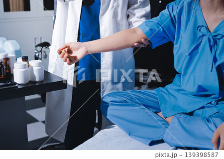Physical therapist assisting a woman with dumbbell exercise 139398587