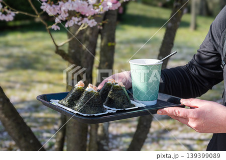 Serene picnic moment. Calm outdoor setting with student enjoying traditional Japanese snacks Serene picnic moment. Calm outdoor setting with student enjoying traditional Japanese snacks 139399089