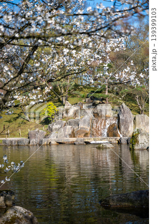Japanese garden with waterfall. Flowing water over rocks in tranquil courtyard setting Japanese garden with waterfall. Flowing water over rocks in tranquil courtyard setting 139399103