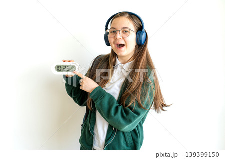 Teenage student holding a clock on white background 139399150