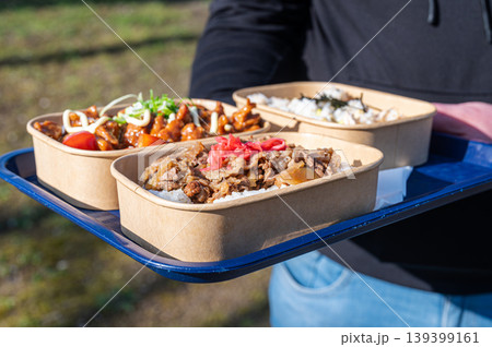 Friends sharing homemade lunch outdoors. Group enjoying sunny day with delicious bento in park 139399161