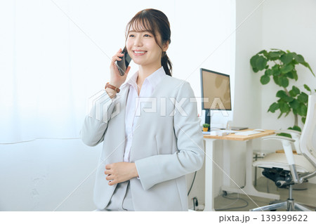 スマートフォンで通話する若い女性ビジネスパーソン・オフィスで電話対応する会社員 139399622