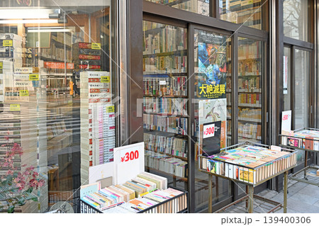 神保町の古本屋店頭 300円均一のワゴンに並ぶ色鮮やかな文庫本と街角 139400306
